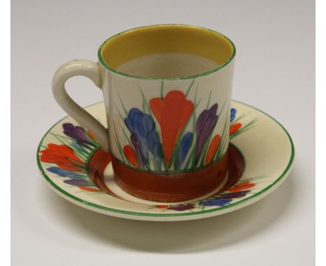 A Clarice Cliff Crocus coffee cup and saucer, decorated with orange, blue and purple flowers, green line borders, printed mar
