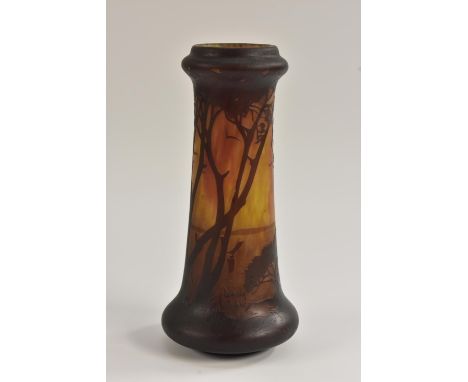 A tapering cylindrical vase in the manner of Daum Nancy, decorated with a continuous lakeside landscape with tall trees and s