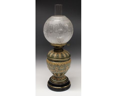 A Doulton Lambeth  oil lamp, of ovoid form applied with floral swags and birds in buff on a mottled blue ground,  the shoulde