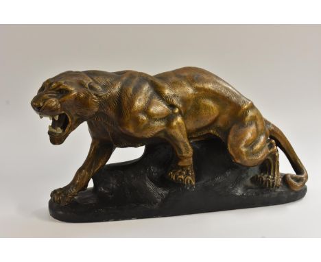 A French Art Deco style model of a snarling panther, the painted plaster body with bronzed effect, he stands poised upon a ro