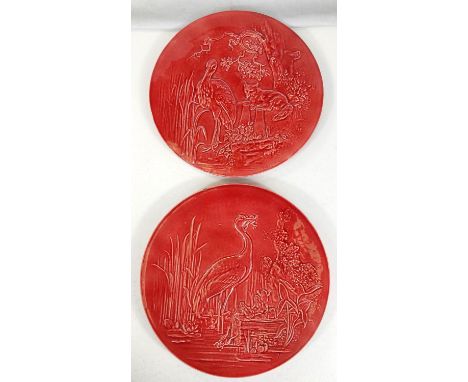 Burmantofts: a pair of circular red glazed wall plates depicting scenes from Aesop's Fables in relief - "Heron eating Frog" a