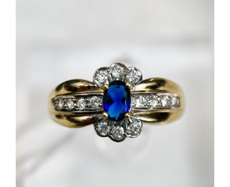 A 9 carat hallmarked gold dress ring set with a blue stone, surrounded by clear stones, 3.4gm, size R 