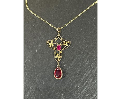 An Art Nouveau style yellow metal pendant stamped 9ct, with central ruby and ruby colour drop, on fine unmarked yellow metal&