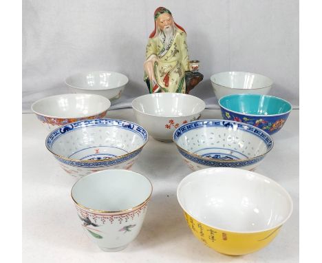 A collection of Chinese ceramic bowls with various decoration and colours to each with mats to base and a ceramic figure of a