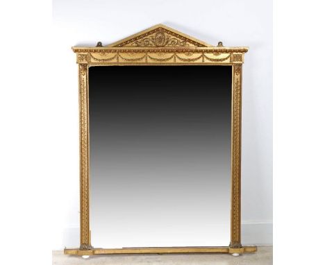 An early 19th century giltwood over-mantel mirror of architectural form, arched pediment, elaborate foliate scroll and swag r