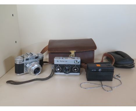 A Braun Super Paxette 35mm camera with leather case and accessories and two Rollei cameras 35 and 110
