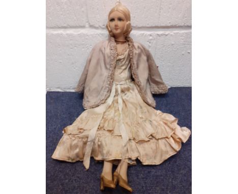 A 1920's French boudoir doll, having painted porcelain lower limbs, a cloth body with silk dress, matching hand muff and jack