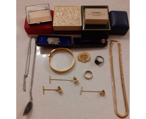 A small quantity of jewellery to include an engraved gold tone bangle, a gold tone wedding band and a silver and black jet si