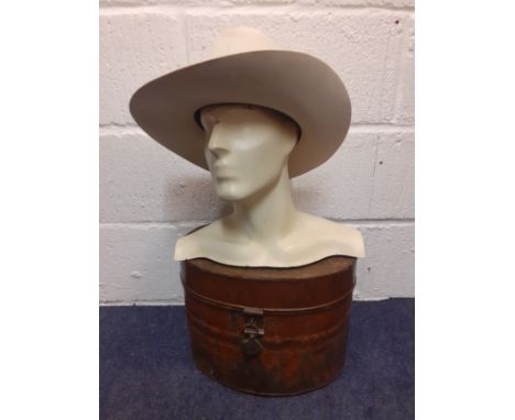 A vintage male mannequin head and shoulders with chiselled features in cream together with a 1920's metal hat box and a Texan