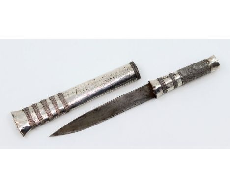   A 19th Century silver Burmese Dha dagger having applied wire decoration to grip and scabbard. Blade length- 10cm. Total len