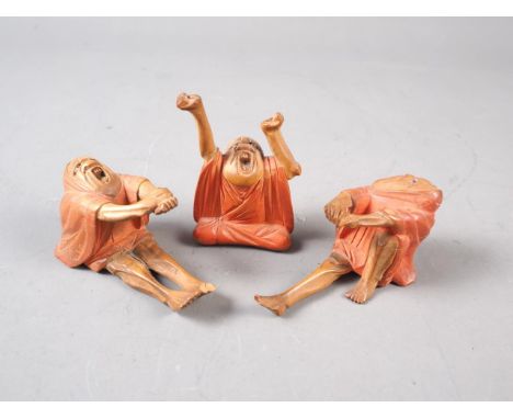 A set of three Japanese carved and painted wood figures, The Awakening of Daruma, 2 1/2" high (one with damaged foot) 