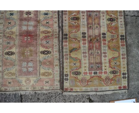 Two Kazak rugs, one with floral centre, the other five star guls on a light ground in shades of ochre, red, brown and yellow,