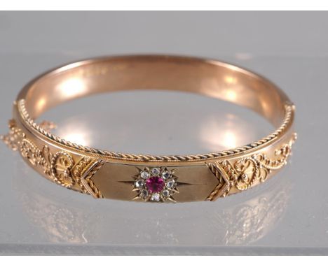A 9ct rose gold hinged bangle, set ruby and diamonds, 2 1/2" wide, 16.9g 