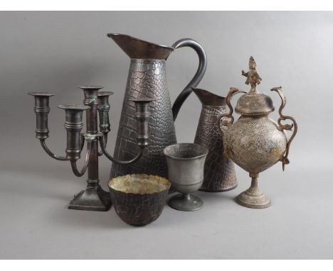 Two crocodile skin embossed copper hot water jugs, a five-light candlestick, a bowl, a goblet and an Indian engraved brass ja