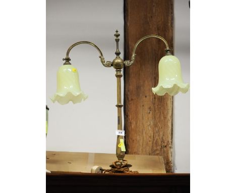 A 1920s brass two-light table lamp with green glass shades, 26" high 