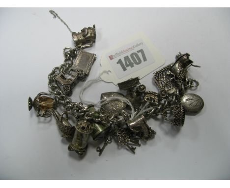 A Curb Link Charm Bracelet, (lacking clasp) suspending numerous novelty charm pendants, including Toby jug, coffee pot, mante