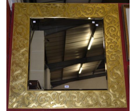 A contemporary gilt framed square wall mirror, the frame with blind fretworked swags.