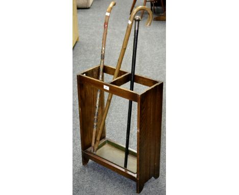 A 1940's oak stick stand; a silver ferruled walking cane; two walking sticks. (4)
