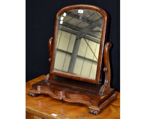 A Victorian flame mahogany dressing mirror, arched plate, serpentine uprights and base, circa 1880.