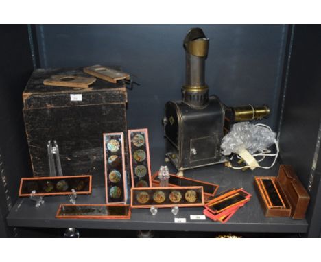 A Victorian 'Magic Lantern' slide projector and a selection of various children's coloured slides, one having mechanical kale