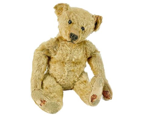 A Steiff teddy bear. Circa 1908, with golden mohair fur, swivel head with black boot button eyes, button in ear, stitched nos