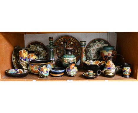 Collection of Gouda pottery including charger, candlesticks, vases and bowls, decorated in typical fashion (one shelf)Chamber