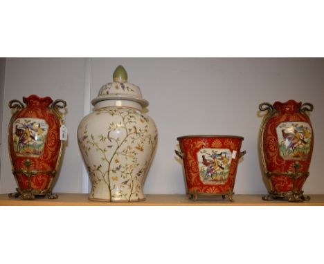 A pair of gilt metal mounted ceramic vases, painted decoration on red ground, central panels depicting exotic birds; a matchi