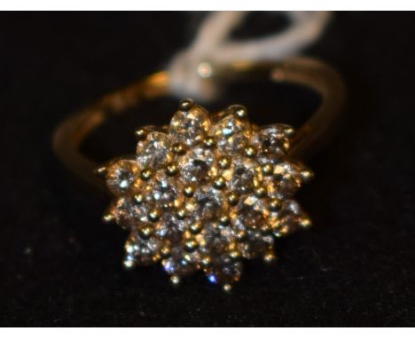 A Champagne/Cognac diamond cluster ring, pave encrusted with nineteen round cut diamonds arranged in a snowflake cluster pane