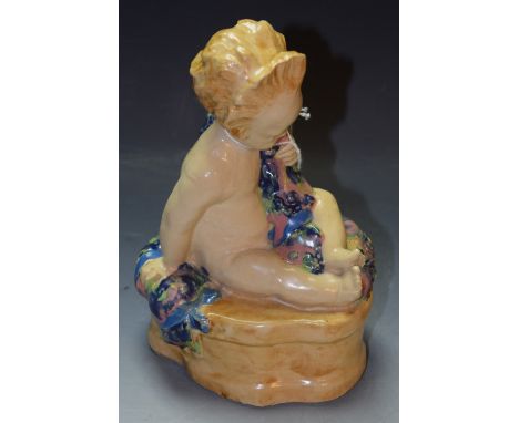 A Hammersmith Pottery figure, Buster Boy, modelled by Phoebe Stabler, modelled as an infant astride a quatrefoil outcrop, hol