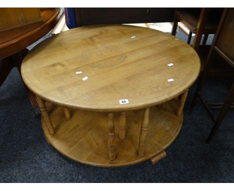 Pale oak circular two-tier coffee table having turned spindle supports with overall inscription to perimeter of Celtic bandin