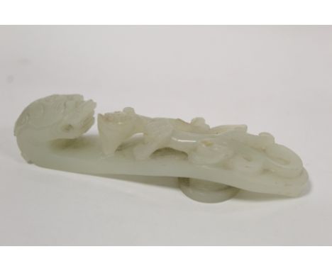 Large Chinese Qing dynasty pale celadon jade belt hook with dragon head terminal, surmounted by a carved figure of a chilong,