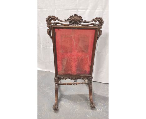 Victorian rosewood firescreen with a later floral fabric, with pierced scrolls, on scroll supports with adjoining under stret