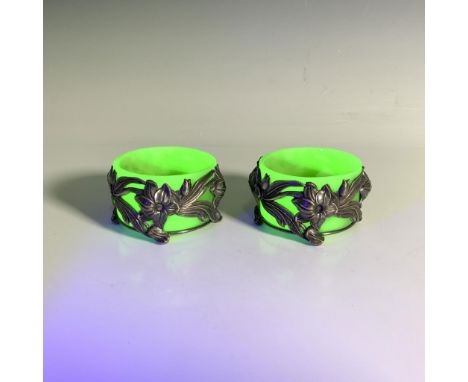 A stunning pair of small uranium glass dishes in a luminous green shade with an attached botanical form metal stand. Issued: 