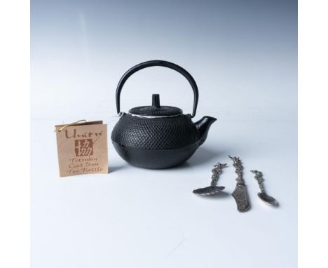 A stunning black cast iron teapot features elegant low relief dots and an abstract art lid, accompanied by three beautifully 
