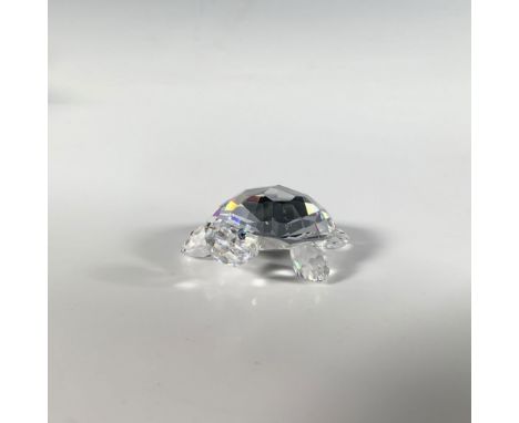 A precious clear cut crystal figure of a small turtle with green and black eyes. Part of the In The Secret Garden collection.