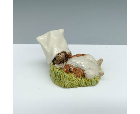 Glossy porcelain figure of a bunny laying down with a bag on its head. Royal Albert Beatrix Potter backstamp. This item has i