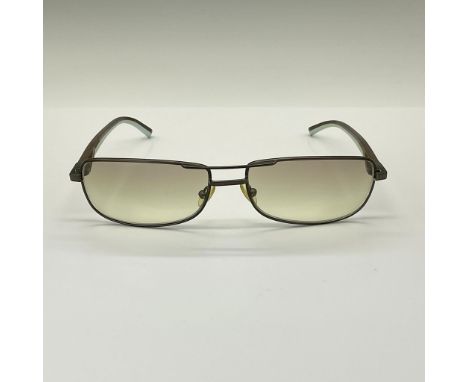 Sunglasses with color code 115, featuring a sleek brown wire frame complemented by rubberized comfort earpieces. The design i