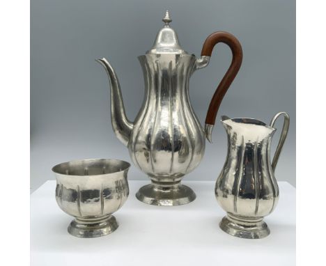 Featuring hammered silver-plated look, includes 1 tall, fluted coffee pot with a curved spout, wooden handle, and ornate fini