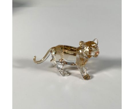 A shimmering, golden, facet-cut crystal figure adorned with blue eyes and an orange nose. SCS 2010 Annual Edition complementa