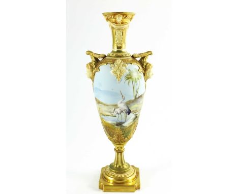 Walter Powell for Royal Worcester, a mask handle vase of slender ovoid form, painted with storks in a desert oasis watering h