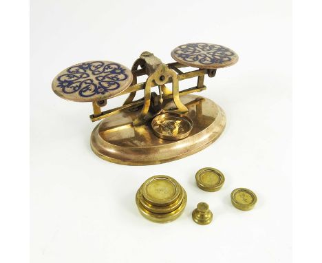 A set of Victorian gilt brass and champlevé enamelled postage scales, each plate with blue knotted foliate wreath, with six g