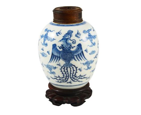 A Chinese blue and white ginger jar, probably 18th century, painted with a fire bird and dragon in a cloudy landscape, carved