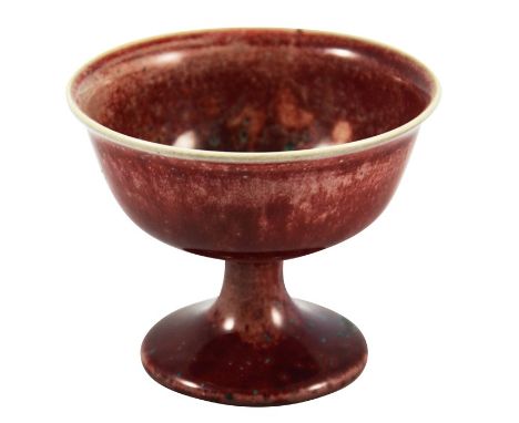 A Ruskin high fired Melba cup, circa 1920, pedestal ogee form, red with speckled purple and green, impressed marks, 8.5cm hig
