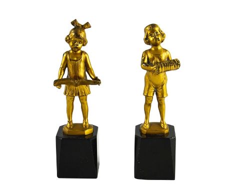 J H Land, a pair of gilt bronze Art Deco figures, modelled as Dutch boy and girl with book and accordion, on black marble bas