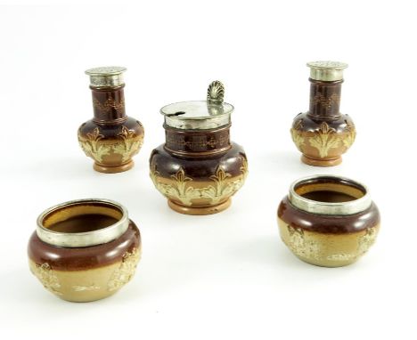 A Doulton Lambeth stoneware cruet, together with two silver mounted salt cellars, sprigged with leaf motifs and hunting taver