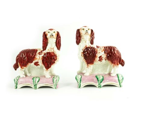 A pair of Staffordshire flatback spaniels, Grace and Majesty, circa 1850, modelled standing, sponge decorated, on leaf moulde
