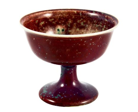 A Ruskin high fired Melba cup, circa 1920, pedestal ogee form, red with speckled purple and green, impressed marks, 8.5cm hig