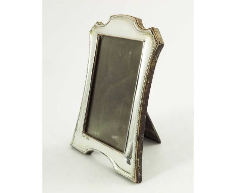 A George V silver photo frame, Green and Cadbury Ltd., Birmingham 1917, beaded and splayed with ogee domed top, bracket feet,