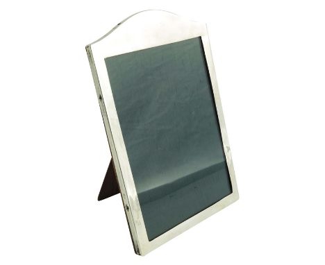 A George V silver photo frame, Charles Edwin Turner, Birmingham 1915, plain rectangular form with arched top, wooden easel ba