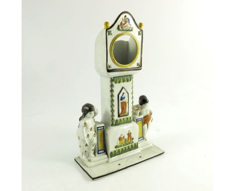 A Dixon, Austin and Co., Sunderland Prattware watch holder, circa 1810, modelled as a longcase clock flanked by children rest